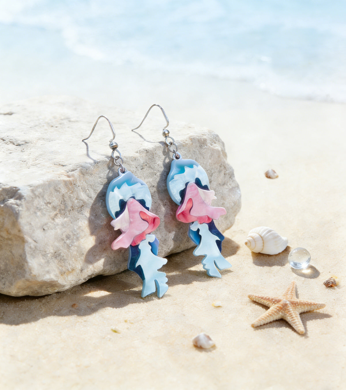 Pink and blue koi fish dangle earrings with silver-tone ear hooks and glossy layered details.